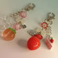 Keychain with fruit and cake charms on a white background