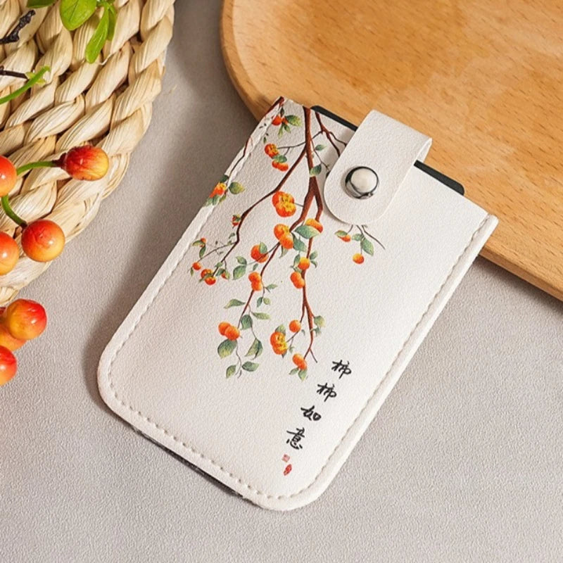 White cardholder with cherry blossom design on a neutral background