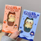 Two Gege Bear kawaii lip balm packaging, one pink and one blue, held by a hand.