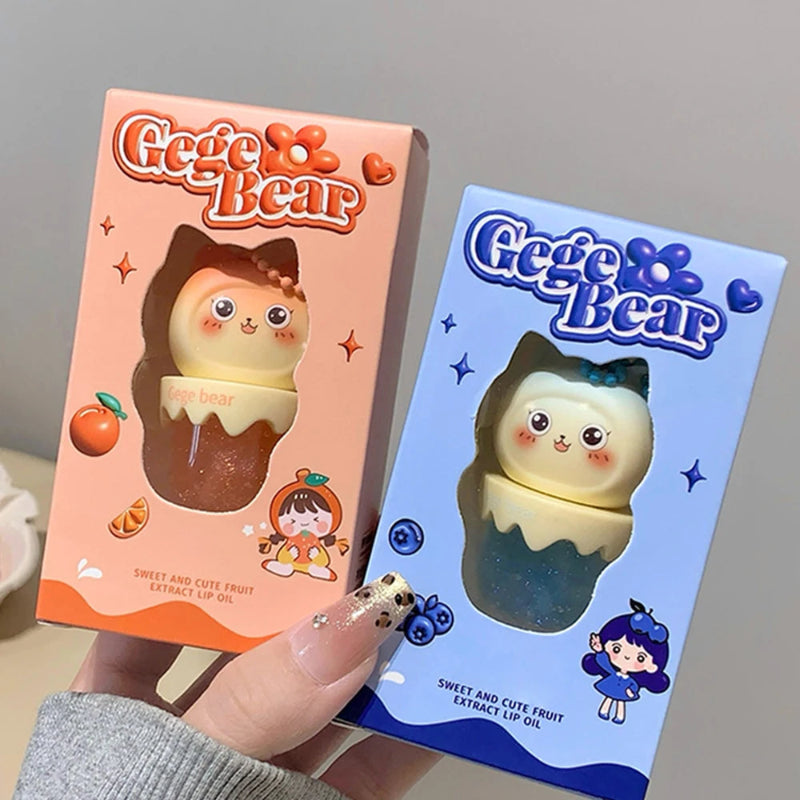 Two Gege Bear kawaii lip balm packaging, one pink and one blue, held by a hand.