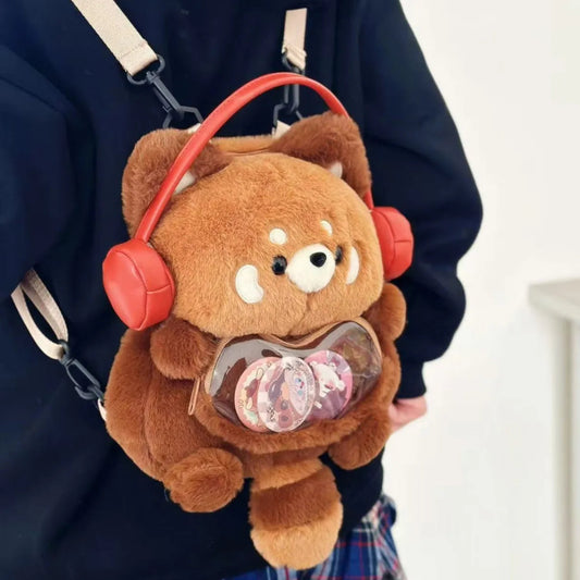 Plush backpack shaped like a red panda with red headphones and a clear pouch filled with pink sequins.