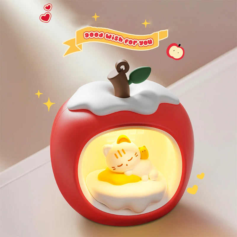 Decorative apple-shaped night light with a Kawaii cat design inside, on a neutral background.