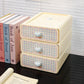 Three-tiered storage box with checkered design and heart-shaped handles on a surface with books.