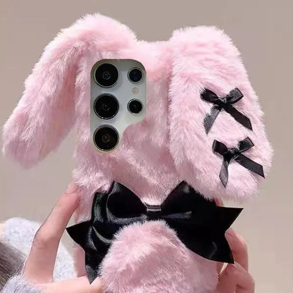 the woman is holding the Kawaii Plush Bunny Samsung Phone Case to display the back of the case , showing off the floppy pink bunny ears.