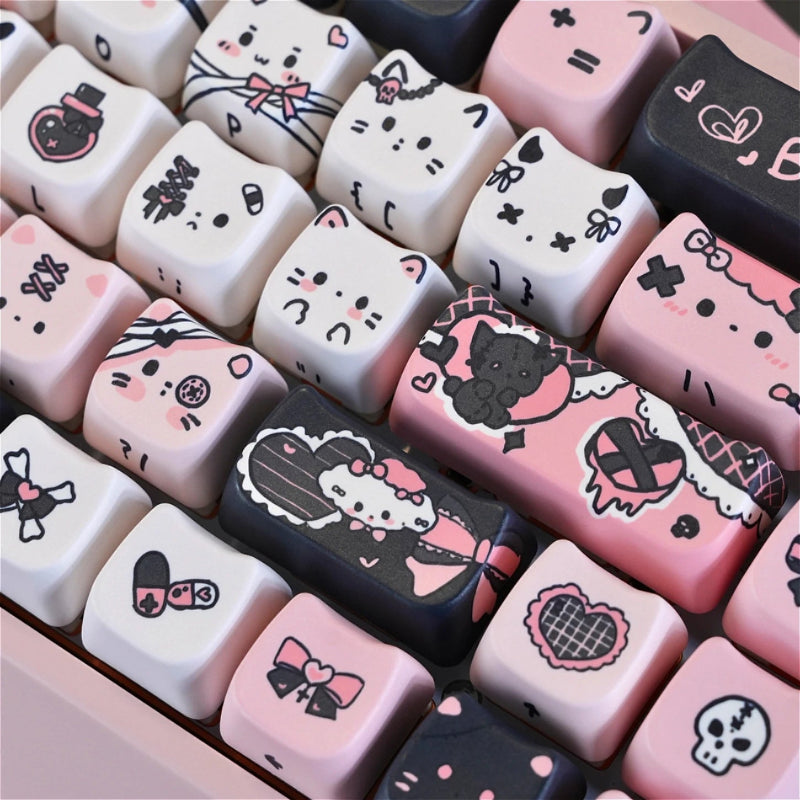 This image is showing a close up of the Kawaii Creepy Cuties Keyboard Keycaps, showing the designs on the keycaps such as cute cat faces  with skull necklace around their ear or bandages round their tiny tummies.