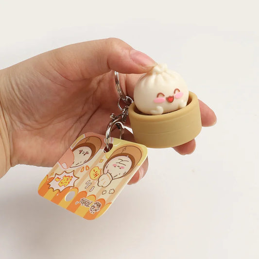 Cute keychain with a cartoon-style bun in a small yellow container held by a hand.
