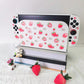 Gaming console with strawberry pattern on a white surface