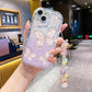 Phone case with butterfly design held by a hand in a blurred indoor setting