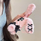 the woman is holding the Kawaii Plush Bunny Samsung Phone Case to display the back of the case , showing off the floppy pink bunny ears.