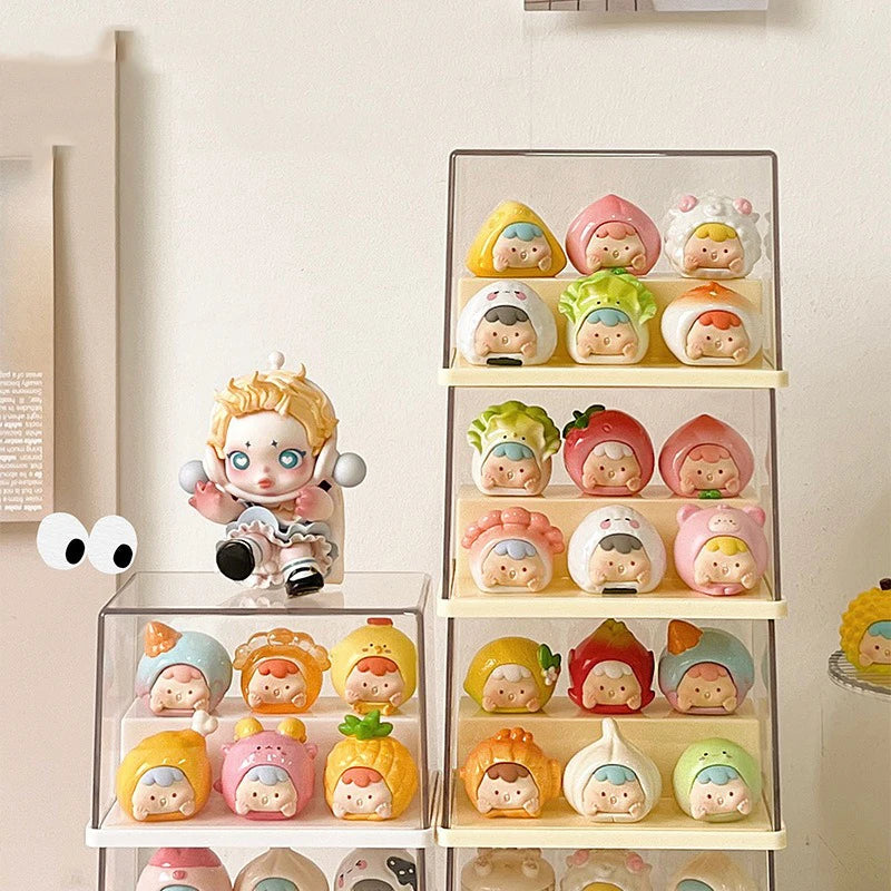 A collection of cute, pastel-colored collectible figurines displayed on clear acrylic shelves and a tabletop against a warm beige wall.