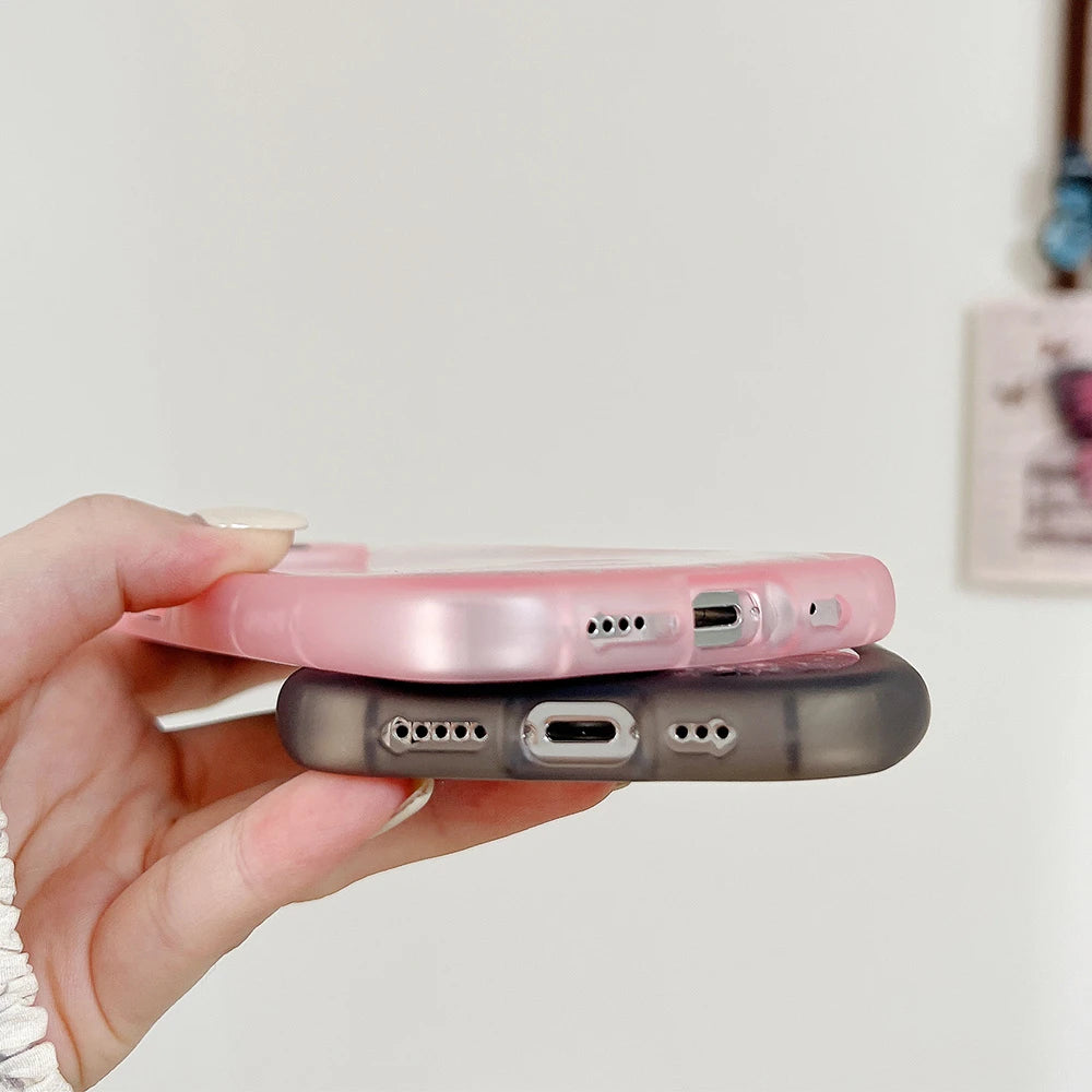 Two phone cases, one pink and one clear, held by a hand against a light background.