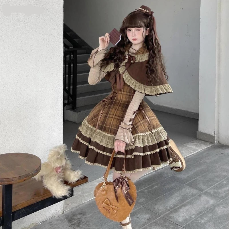 Person wearing a brown and beige plaid dress with a matching handbag, standing indoors.
