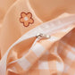 Close-up of a checkered fabric with a zipper and a flower design on an orange background