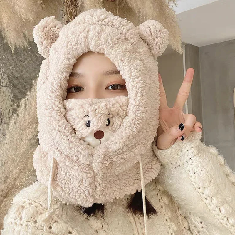 Person wearing a fluffy bear-like hat with a mask, making a peace sign.