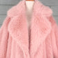 Pink fur coat on a mannequin against a gray background
