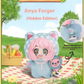 Plush toy with pink hair and cat ears on a picnic blanket with a scenic background