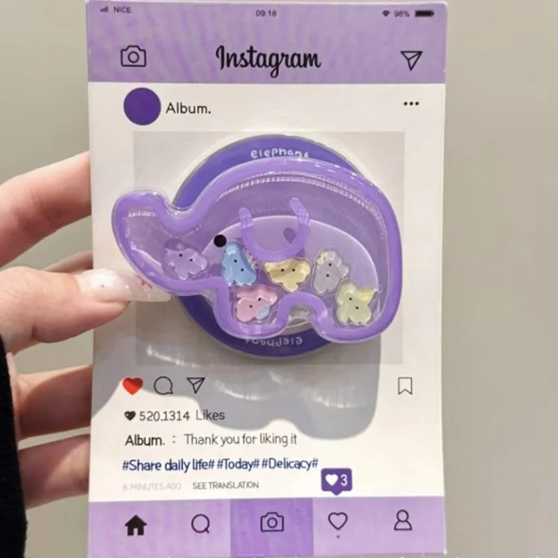 a woman holding a kawaii cute elephant quicksand phone grip , this is in the color purple with colorful elephant faces inside on an Instagram background