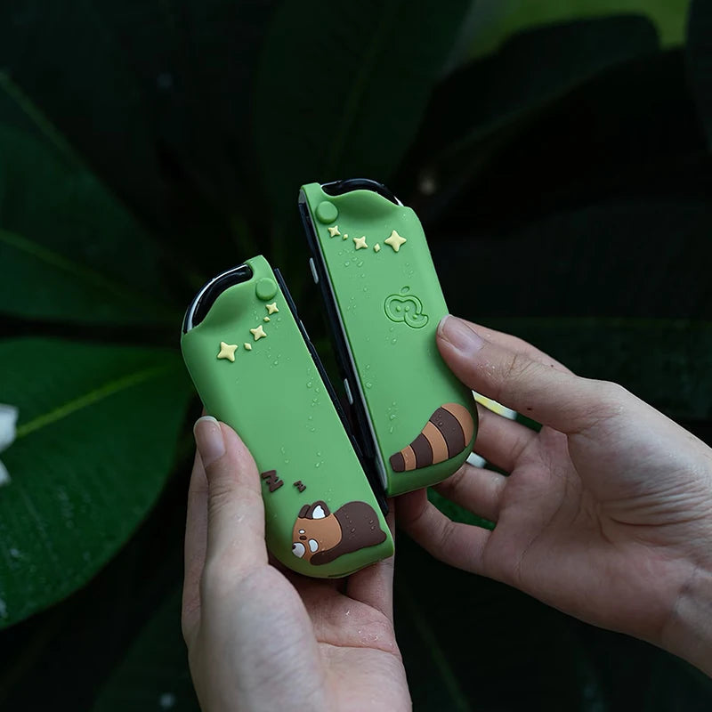 Green silicone keychain with kawaii design held by hands against a dark background