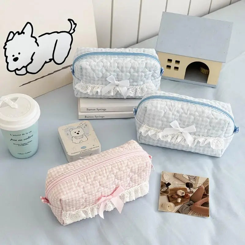 Set of small pencil cases with lace details on a light surface.