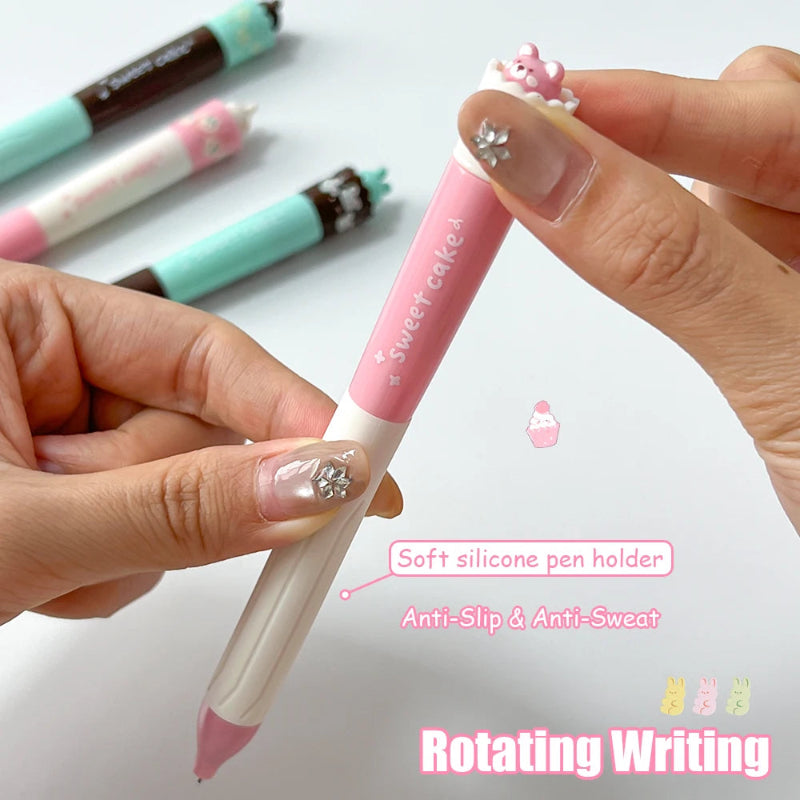 Person holding a pink pen with decorative elements, surrounded by other pens on a light background.