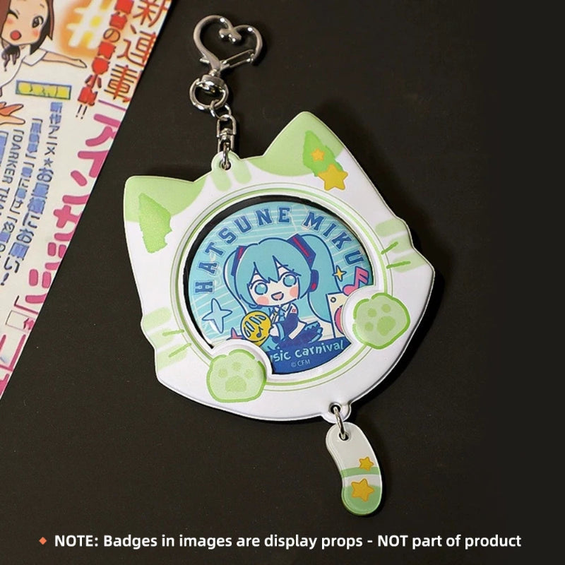 A cat-shaped collectible keychain or badge holder with a silver clasp and a small dangling charm, shown on a dark surface. The main body is white with light green cat-ear shapes and paw-print accents, and the center displays a circular anime character badge reading Hatsune Miku.