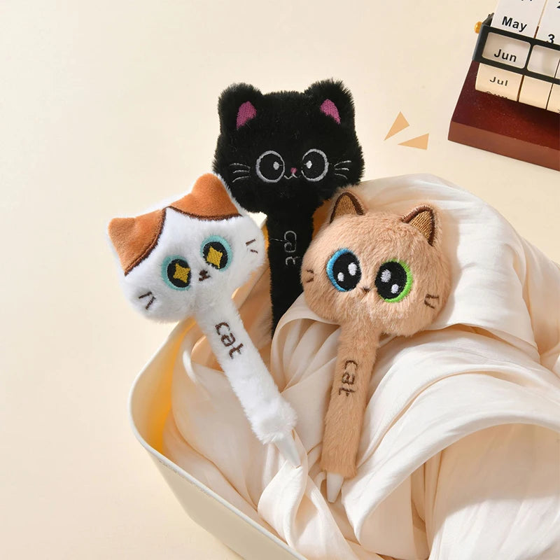 Cat-shaped pens with a black, orange, and beige design in a white bowl on a beige background.