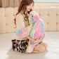 Plush pastel turtle being held by a woman on a white floor