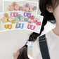 Colorful hair clips displayed on a white card with a person wearing a blue hair clip.