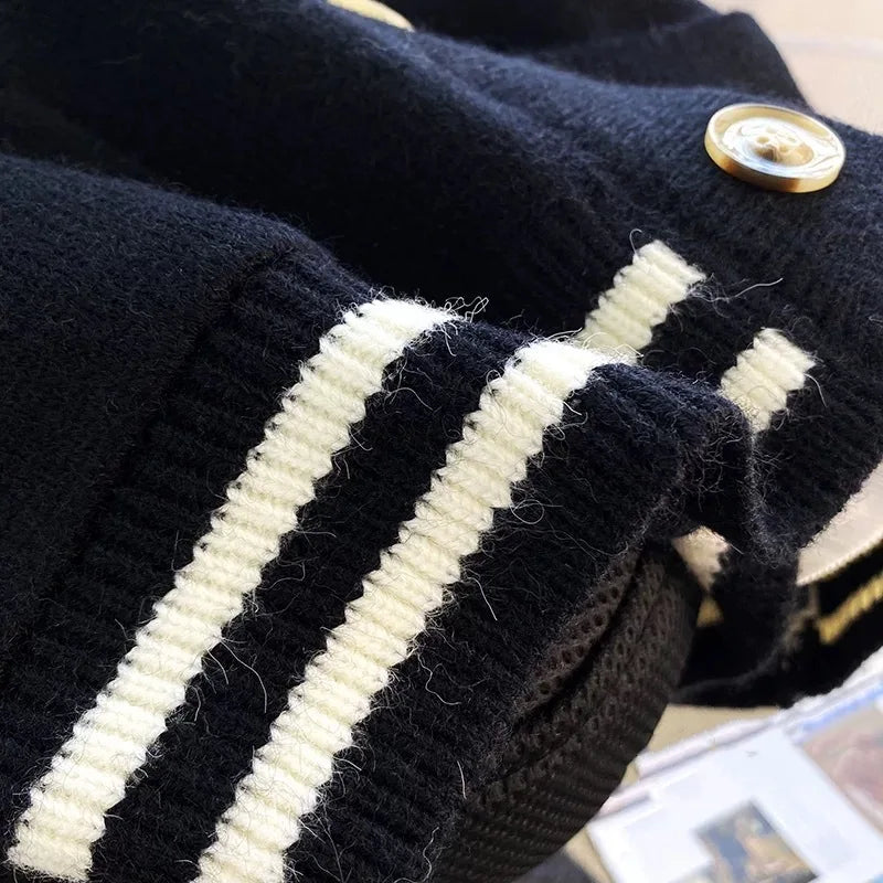 Sweet Teddy Bear Cardigan black edition with a bear sown into the chest area whilst the sleeves have large white stitches where they have been joined and black strips on the wrist cuffs with white, black and white trim. this image is displaying a close up of the lower trim.