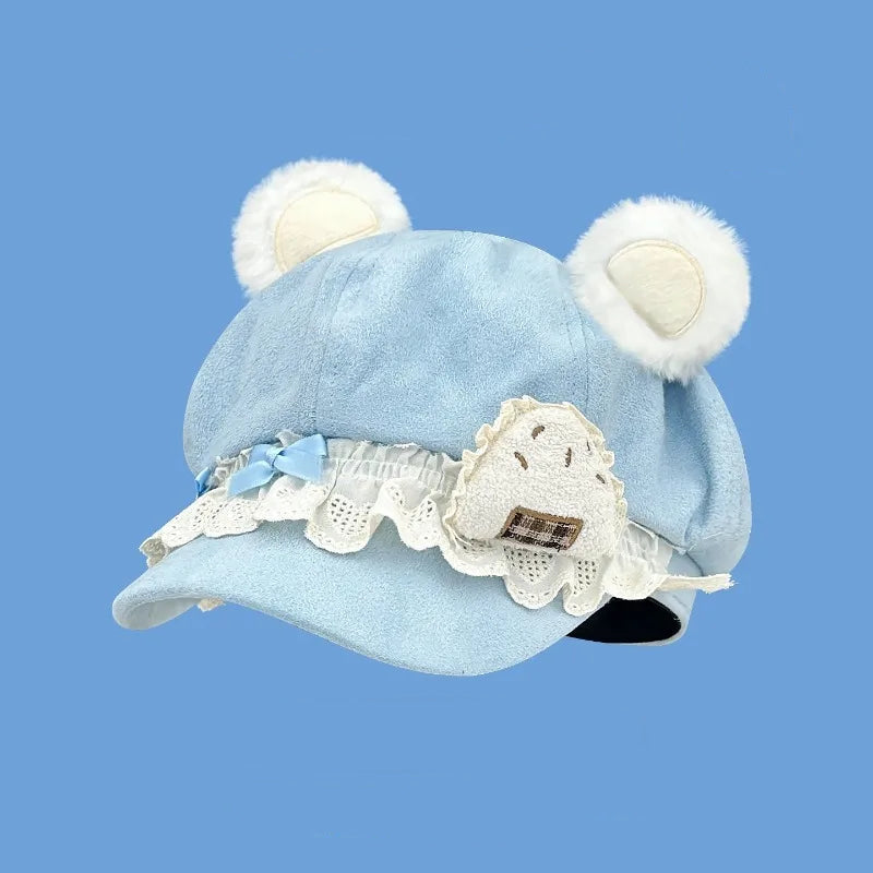 Blue hat with white bear ears and lace details on a blue background