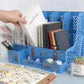 Blue desk organizer with stationery items on a light blue surface