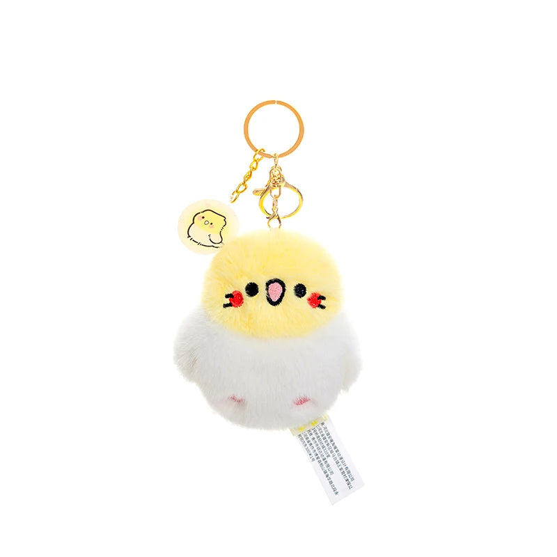 kawaii yellow and white bird plushie keychain on a white background