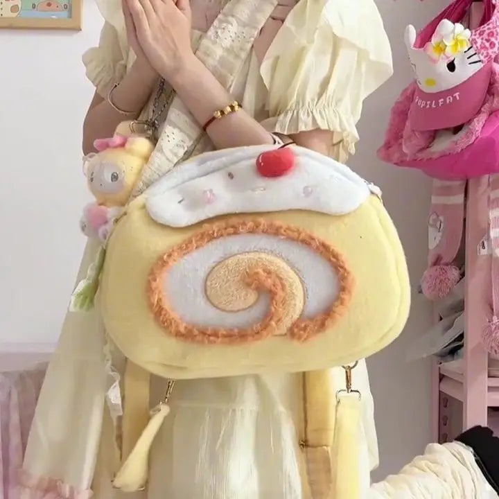 Person holding a cute, plush pastry-shaped bag with a cherry on top.