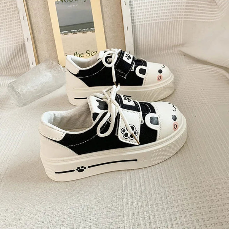 Pair of black and white cat-themed sneakers on a light background