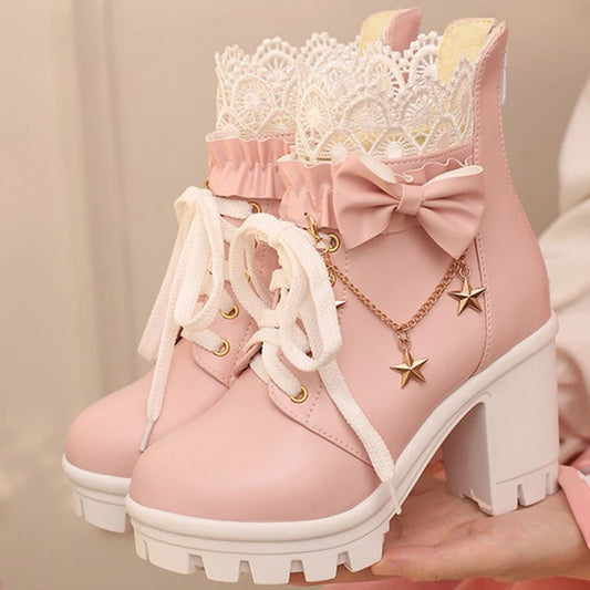 Pink ankle boots with white laces, bow, and star charms on a beige background