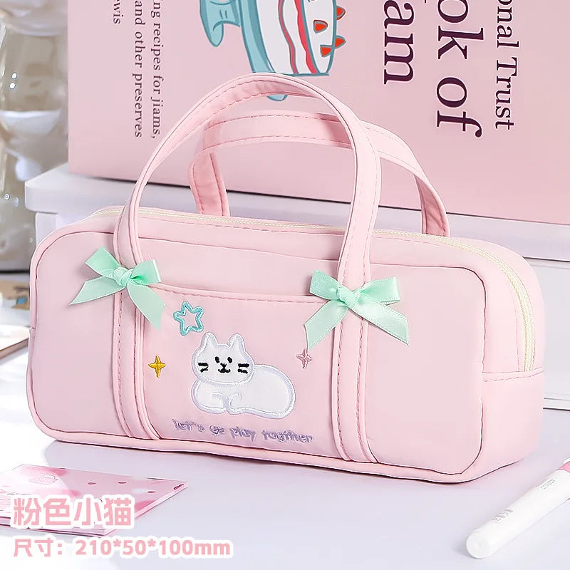 Pink pencil bag with cat design and bows on a light background