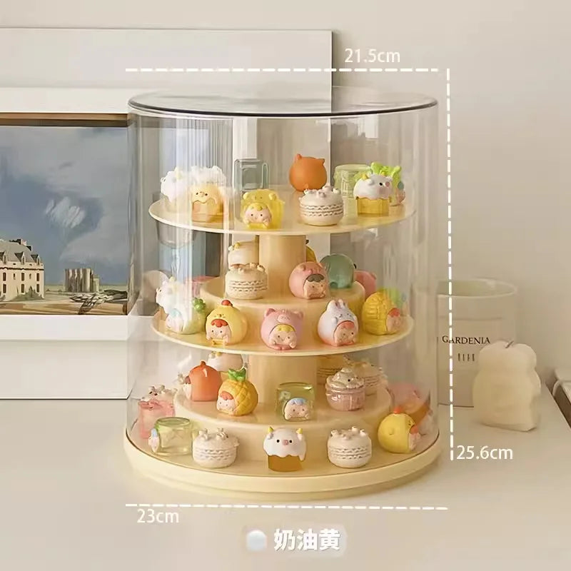 A 4-tier rotating acrylic display stand with a clear cylindrical dome cover and cream-colored base, shown on a tabletop with dimension labels overlaid (21.5 cm top, 25.