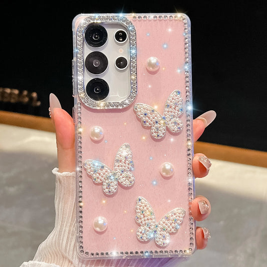 Pink phone case with butterfly designs and rhinestones held by a hand.