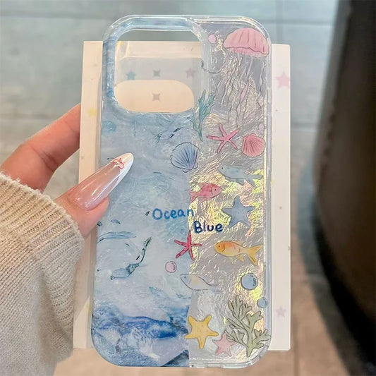 Phone case with ocean-themed design featuring fish, starfish, and shells held by a person.
