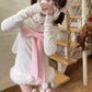 Person wearing a white outfit with pink accents, standing by a staircase.