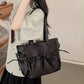 Woman holding a large black handbag indoors