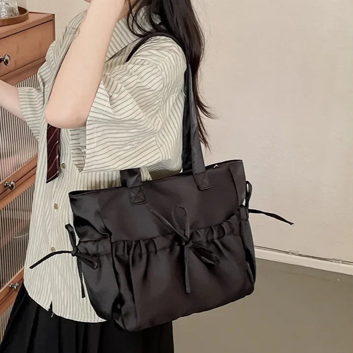 Woman holding a large black handbag indoors