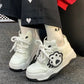 White sneakers with paw print design on grey floor