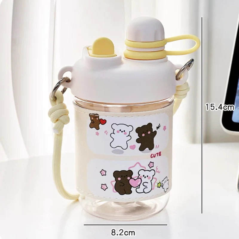  cute water bottle with cartoon designs held by hands against a blurred background. displaying the measurements of it.