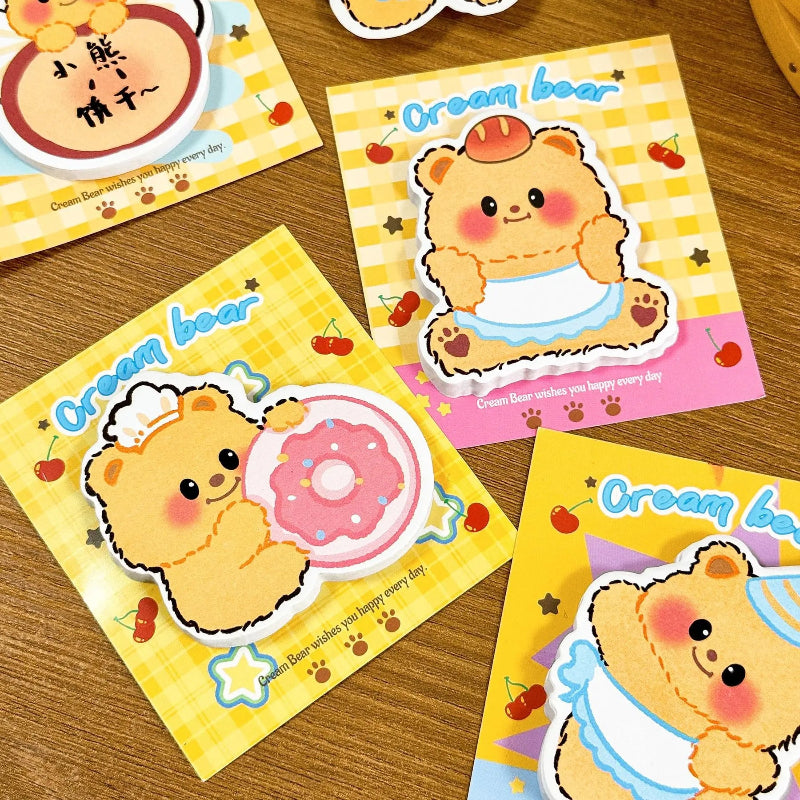 4pcs Creamy Bear Kawaii Sticky Notes in three different designs on a wooden desk.