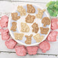 Set of woodland animal-themed cookie cutters on a white plate with a wooden background.