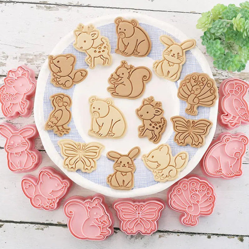 Set of woodland animal-themed cookie cutters on a white plate with a wooden background.