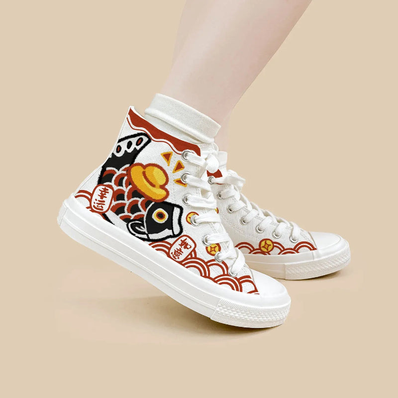 A pair of white high-top canvas sneakers with traditional Japanese fish and wave patterns in red, black, and yellow, shown on a model's feet against a solid beige background.