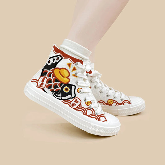 A pair of white high-top canvas sneakers with traditional Japanese fish and wave patterns in red, black, and yellow, shown on a model's feet against a solid beige background.
