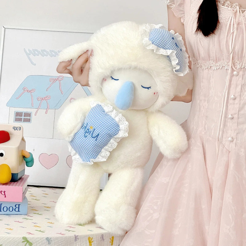 Cute whilte lamb plushie with blue accents held by a person in a pink dress, with toys and a drawing in the background.